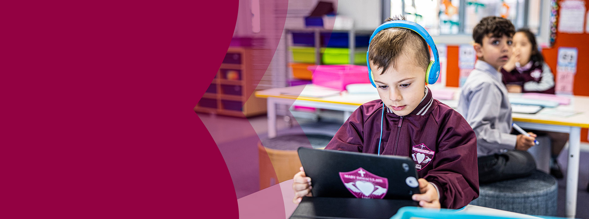 Student wearing headphones working on his tablet at Mary Immaculate Primary School Quakers Hill