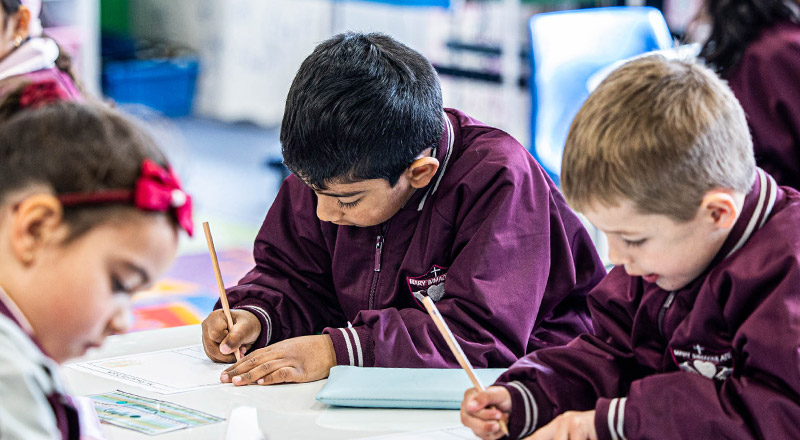 Students writing at their desks in the classroom at Mary Immaculate Primary School Quakers Hill