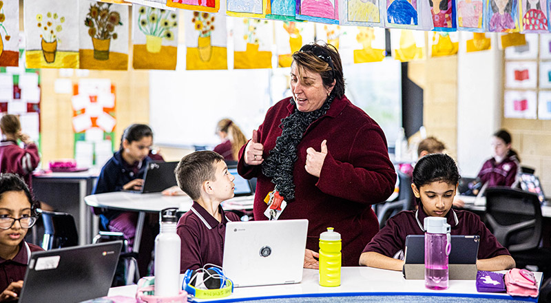 Teacher assisting students in the classroom at Mary Immaculate Primary School Quakers Hill