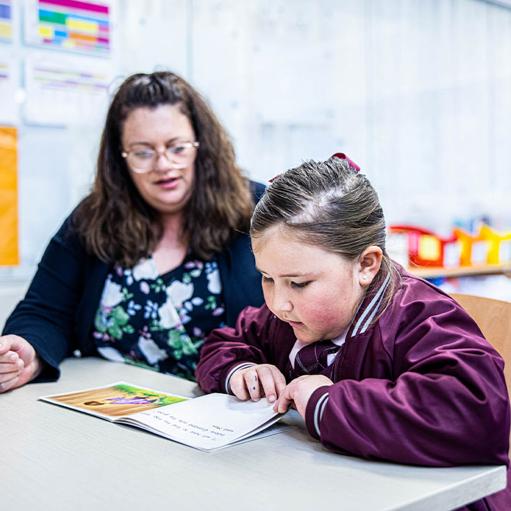 Student reading with her teacher in the classroom at Mary Immaculate Primary School Quakers Hill