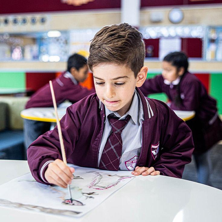 Student painting in the classroom at Mary Immaculate Primary School Quakers Hill
